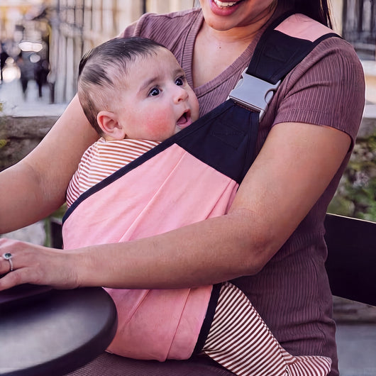 Mother wearing the Cradle & Cove sling in Blush outdoors
